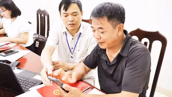 Cán bộ Trung tâm phục vụ hành chính công xã Thung Nai hướng dẫn người dân thôn Thống Nhất làm thủ tục.