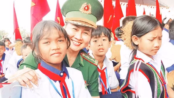Em H'Goa, học sinh lớp 6A2, Trường phổ thông nội trú liên cấp tiểu học và trung học cơ sở Thuận An cùng mẹ đỡ đầu trong ngày khai giảng năm học mới (Ảnh NGUYỄN NAM)