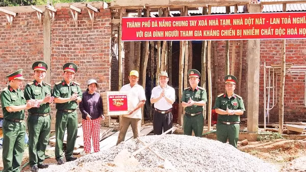 Đại tá Đinh Văn Hưng, Chính ủy Bộ Chỉ huy quân sự thành phố Đà Nẵng tặng quà gia đình thuộc diện xóa nhà tạm tại xã Sông Kôn (Ảnh QUANG CƯỜNG)