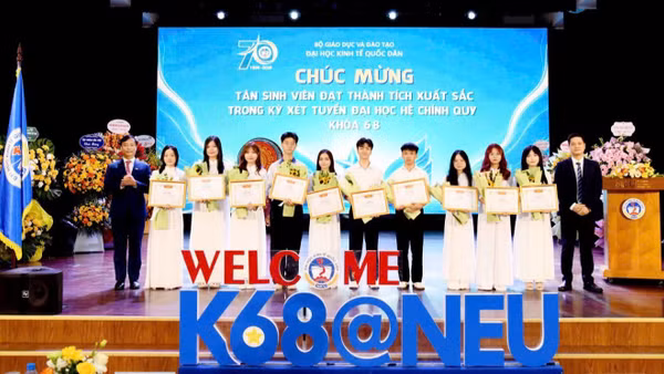 Giám đốc Đại học Kinh tế Quốc dân chúc mừng các tân sinh viên đạt thành tích xuất sắc. (Ảnh: TUẤN ANH)
