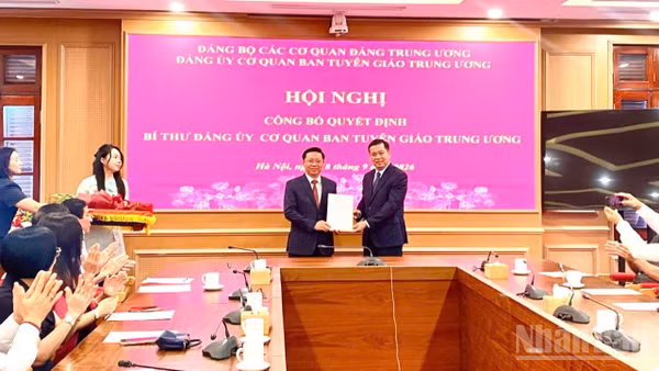 Đồng chí Nguyễn Long Hải trao Quyết định của Ban Thường vụ Đảng ủy các cơ quan Đảng Trung ương cho đồng chí Trần Thanh Lâm. (Ảnh: QUỲNH CHI)