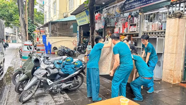 Lực lượng chức năng phường Thanh Xuân hỗ trợ người dân di chuyển đồ đạc đến nơi tạm cư.