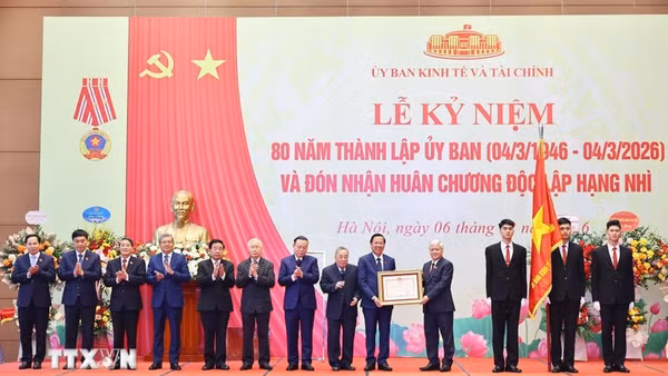 Phó Chủ tịch Thường trực Quốc hội Đỗ Văn Chiến trao Huân chương Độc lập hạng Nhì cho Ủy ban Kinh tế và Tài chính của Quốc hội. (Ảnh: Minh Đức/TTXVN)