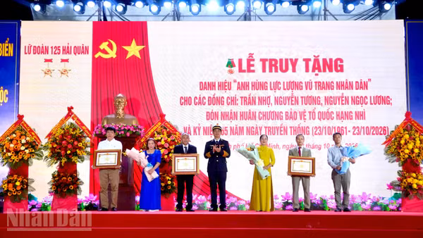 Thủ trưởng Quân chủng Hải quân trao danh hiệu Anh hùng Lực lượng vũ trang nhân dân cho thân nhân ba liệt sĩ thuộc Đoàn tàu không số. (Ảnh: LÊ THÀNH)