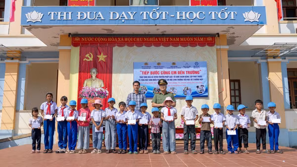 Các thành viên đoàn công tác tặng quà cho học sinh có hoàn cảnh đặc biệt khó khăn. (Ảnh: NHẬT QUANG)