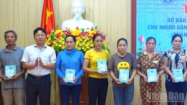Trao tặng thẻ bảo hiểm y tế cho hộ nghèo tại tỉnh Quảng Trị. (Ảnh: Hương Giang)