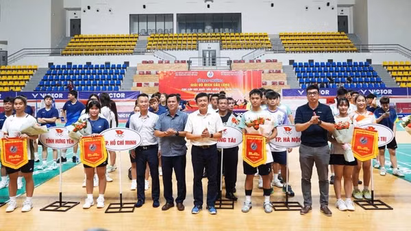 Các đại biểu tặng cờ lưu niệm và hoa cho đại diện các đoàn vận động viên (Ảnh: HG)