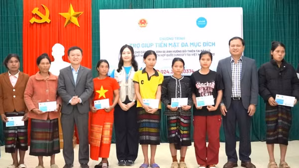 Các đại biểu trao trợ giúp tiền mặt cho hộ gia đình bị ảnh hưởng thiên tai ở xã Kim Ngân (Ảnh: NH)