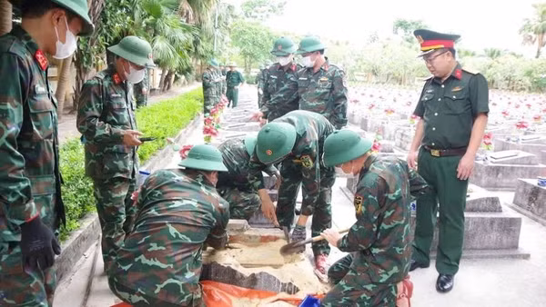Lực lượng chức năng thực hiện lấy mẫu tại nghĩa trang Ba Dốc, tỉnh Quảng Trị. (Ảnh: QS)