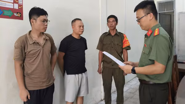 Cơ quan An ninh điều tra Công an thành phố tống đạt các quyết định đối với Chu Đức Anh và Nguyễn Trung Hiếu. (Ảnh: Công an cung cấp)
