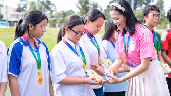 Cô Nguyễn Thị Minh Tâm, Chủ nhiệm câu lạc bộ thanh niên khuyết tật tỉnh Đồng Tháp trao quà cho học sinh có hoàn cảnh khó khăn. (Ảnh: LÝ OANH)