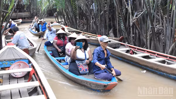 Du khách nước ngoài tham quan, trải nghiệm chèo xuồng tại cù lao Thới Sơn, phường Thới Sơn, tỉnh Đồng Tháp.