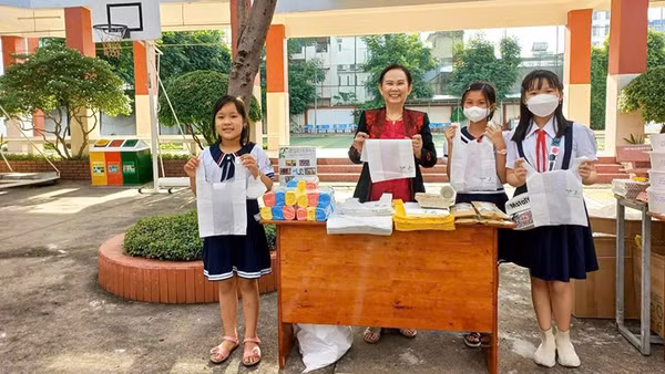 Chị Phan Thị Thúy Phượng (giữa) giới thiệu và tuyên truyền với học sinh về những lợi ích của túi ni-lông sinh học tự hủy. (Ảnh: nhân vật cung cấp)