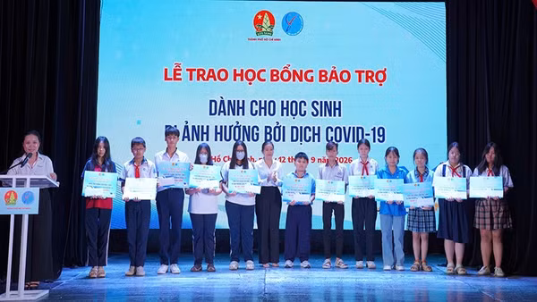 Đại diện Ban tổ chức trao học bổng bảo trợ dành cho các em học sinh bị ảnh hưởng đại dịch Covid-19. (Ảnh: CTV)
