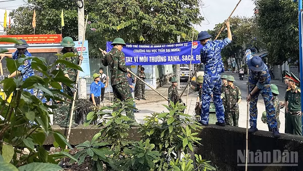 Thanh niên lực lượng vũ trang tham gia dọn vệ sinh, khơi thông dòng chảy rạch Nhà Nuôi. (Ảnh: HOÀNG LIÊM)