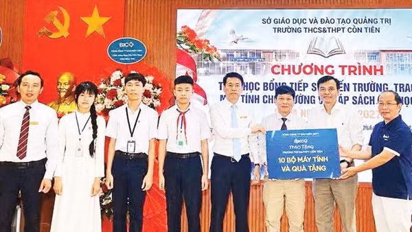 Đại diện Công ty cổ phần Kaopiz Holdings và Báo Nhân Dân trao máy tính tặng Trường THCS & THPT Cồn Tiên (Ảnh QUANG HUY)