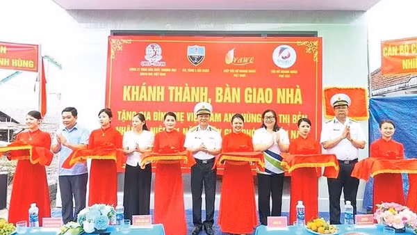 Các đại biểu và gia đình Mẹ Việt Nam Anh hùng Bùi Thị Bẻn cắt băng khánh thành nhà (Ảnh CTV)