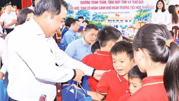 Bí thư Thành ủy Hà Nội Trần Đức Thắng tặng quà học sinh có hoàn cảnh khó khăn tại Trường tiểu học Thiên Đức, xã Phù Đổng (Ảnh THÁI QUANG)