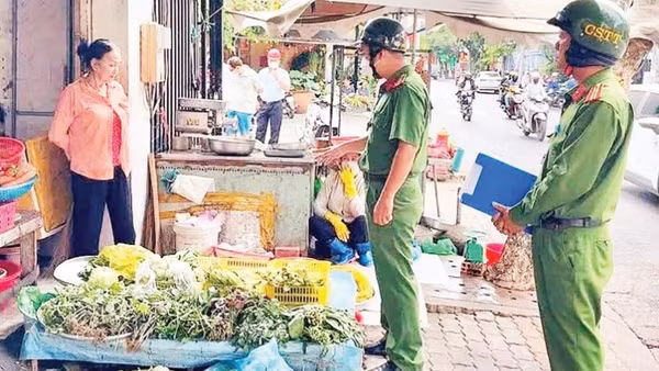 Công an phường Tân Hưng nhắc nhở người dân chấp hành trật tự vỉa hè khi buôn bán.