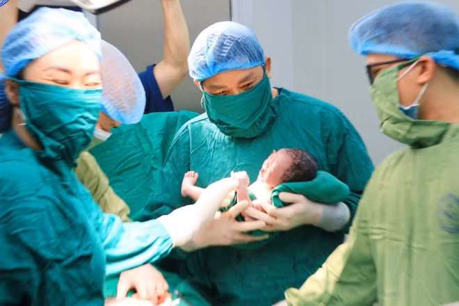 Giáo sư, Tiến sĩ Nguyễn Duy Ánh, Giám đốc Bệnh viện Phụ sản Trung ương thực hiện cắt dây rốn chậm cho em bé. 