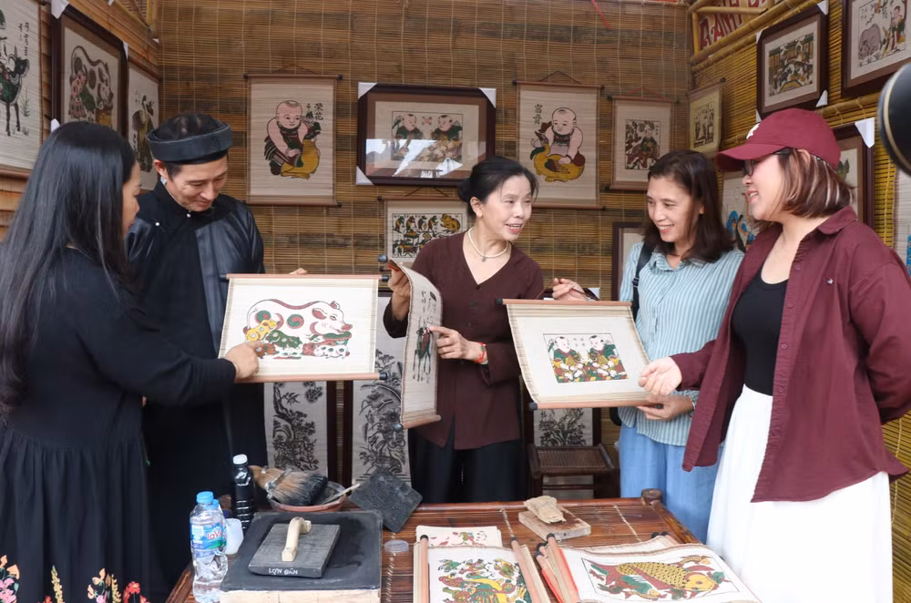 Nghệ nhân tranh dân gian Đông Hồ giới thiệu tác phẩm với du khách tại Festival “Về miền di sản Bắc Ninh-2026”.