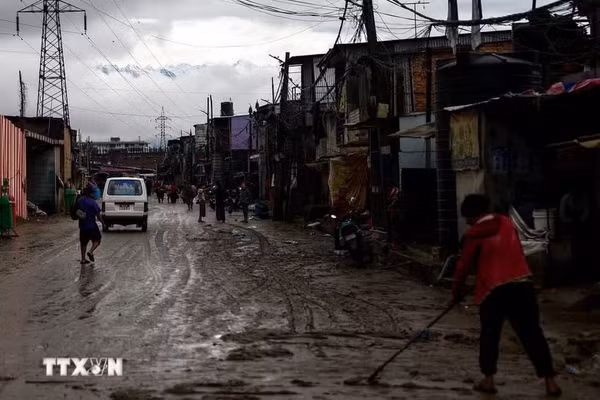 Người dân dọn bùn trên đường phố sau trận lũ quét tại Kathmandu, Nepal, ngày 5/10/2025. (Ảnh: THX/TTXVN)