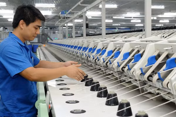 Công nhân Công ty trách nhiệm hữu hạn Một thành viên Dệt 8-3 vận hành dây chuyền sản xuất sợi. (Ảnh: TRẦN HẢI)