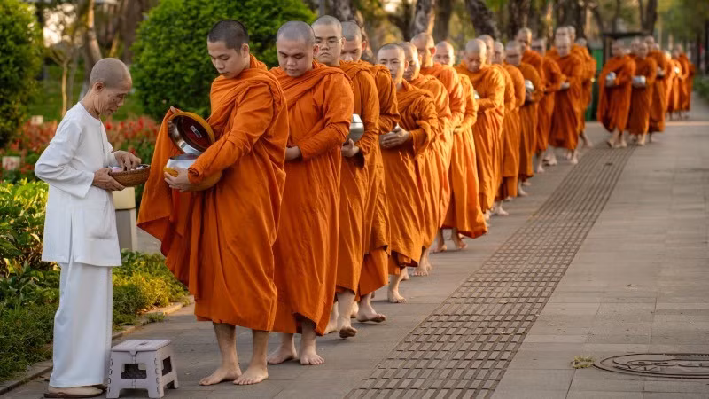 Đoàn khất thực đi qua công viên trước Ủy ban nhân dân thành phố Huế sáng 1/3. (Ảnh: Lê Đình Hoàng)
