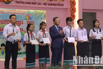 Đại sứ Việt Nam tại Lào Nguyễn Minh Tâm trao tặng phần thưởng cho các em học sinh có thành tích tốt trong năm học 2024-2025. (Ảnh: HẢI TIẾN)