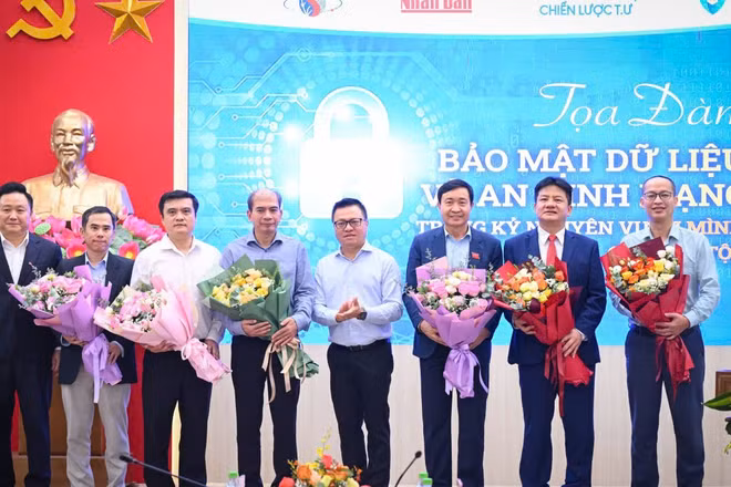 Tổng Biên tập Báo Nhân Dân Lê Quốc Minh và Phó Tổng Biên tập Báo Nhân Dân Phan Văn Hùng tặng hoa các diễn giả của buổi tọa đàm về bảo mật dữ liệu và an ninh mạng. (Ảnh: THÀNH ĐẠT)