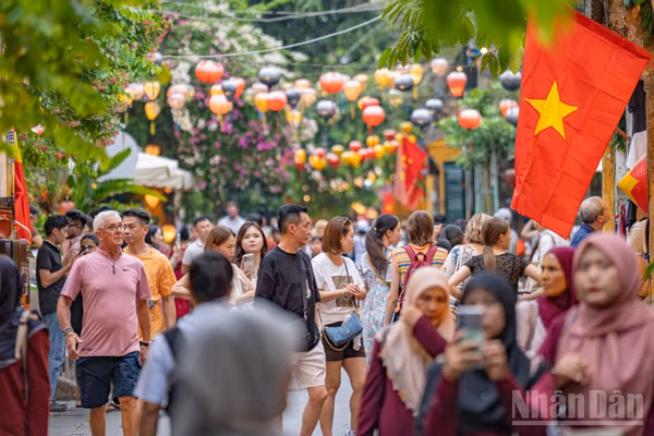 Lá Quốc kỳ tung bay trên những tuyến phố đông nghẹt người khiến không gian phố cổ Hội An trong những ngày này thêm phần trang trọng.