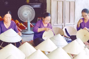Bà Nguyễn Thị Kiềm (bên trái) cùng nhóm thợ giữ nghề chằm nón lá Vân Thê.