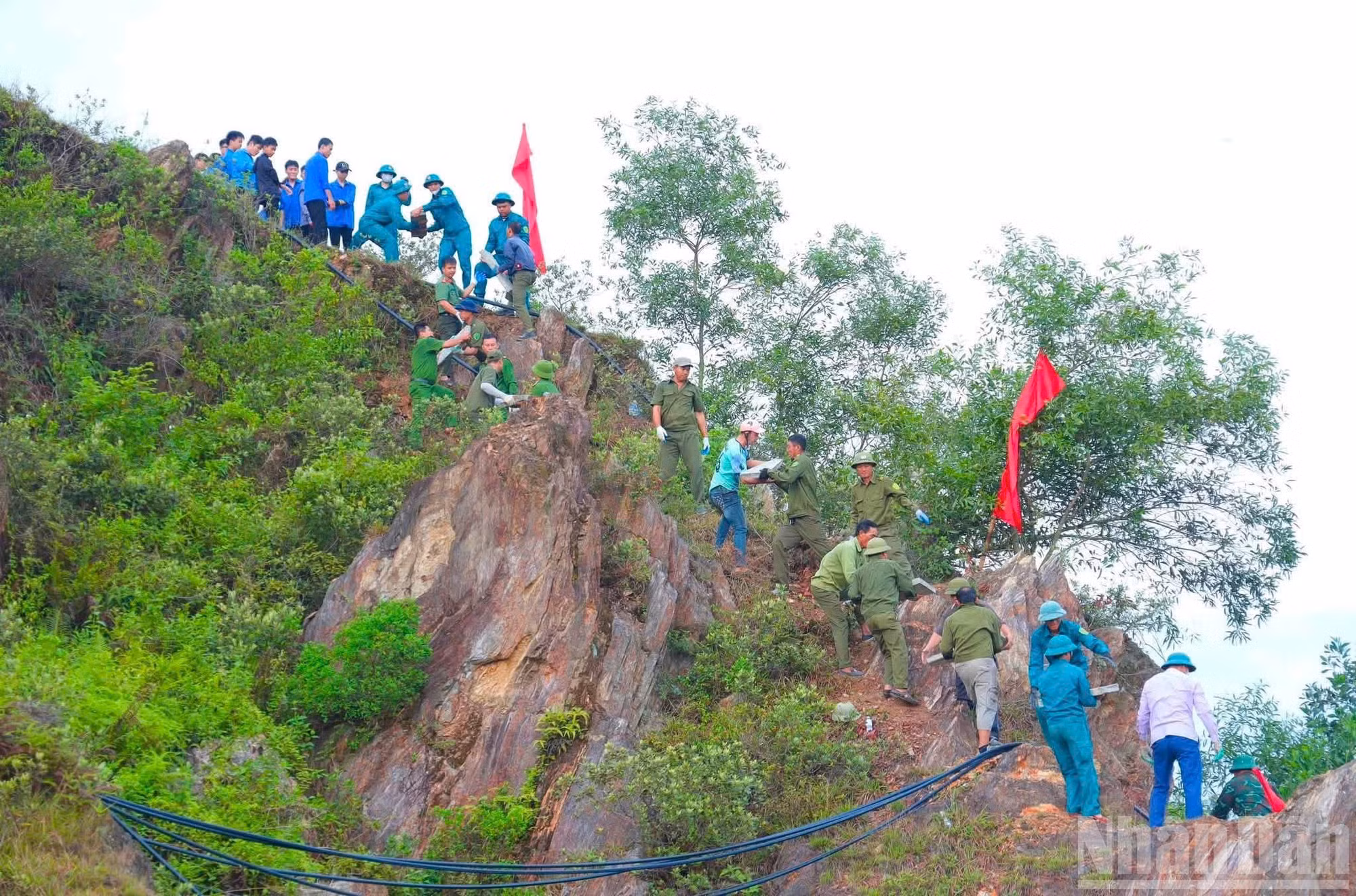 Hàng nghìn người chung sức tái tạo dòng chữ “Bác Hồ sống mãi” trên núi Nhón. (Ảnh: H.H)