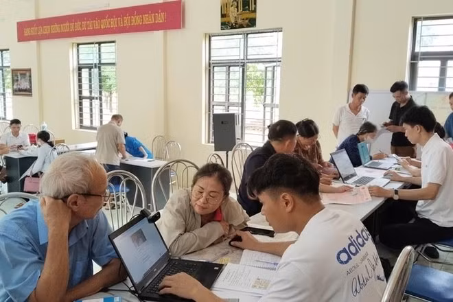Cán bộ thôn Hồng Kỳ, xã Trung Giã (Hà Nội) hướng dẫn người dân cách sử dụng ứng dụng eTax Mobile, iHanoi và khai báo làm sạch dữ liệu đất đai. (Ảnh: LÊ TRƯỜNG) 