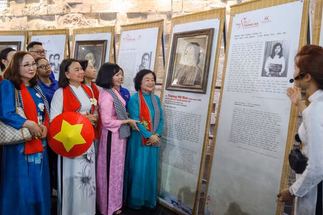 Nguyên Phó chủ tịch nước Trương Mỹ Hoa (áo dài xanh, bên phải) bên tác phẩm chân dung mình được nghệ nhân tạo tác trên lá sen Việt Nam. (Ảnh: Ban tổ chức cung cấp)