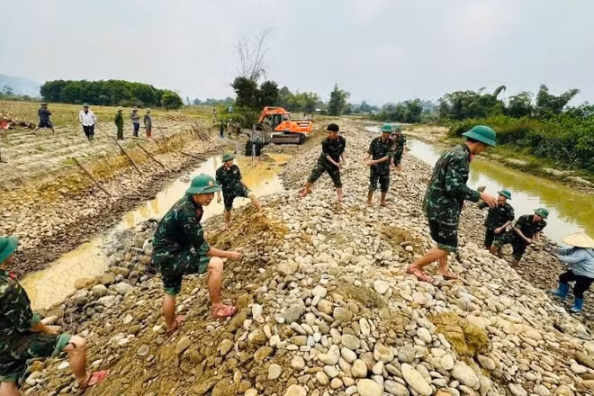 Cán bộ, chiến sĩ Trung đoàn 832 giúp dân gia cố, ngăn sạt lở bờ suối Cái, xã Đại Từ. (Ảnh: DUY ĐỨC)
