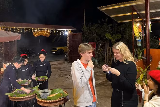 Du khách quốc tế trải nghiệm ẩm thực bản địa tại khu du lịch hồ Ba Bể trong kỳ nghỉ lễ vừa qua. (Ảnh: TUẤN SƠN)