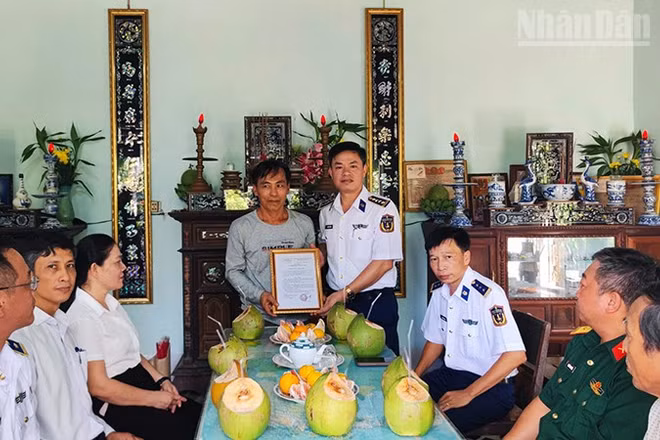 Đại tá Nguyễn Tiến Đức trao quyết định phụng dưỡng Mẹ Việt Nam Anh hùng Lâm Thị Hoạnh. (Ảnh: NAM TRUNG)