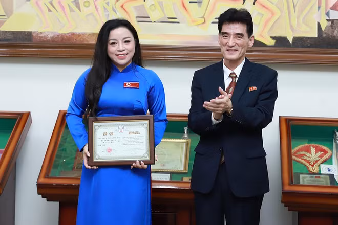Đại sứ Ri Sung Guk trao cúp và bằng khen cho Nghệ sĩ Ưu tú Tố Nga. (Ảnh: Nhân vật cung cấp)