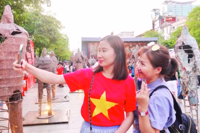 Du khách thích thú với các hoạt động trong chuỗi sự kiện “Sắc màu thành phố Bác” tại đường đi bộ Nguyễn Huệ. (Ảnh MẠNH HẢO)