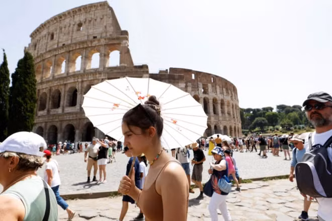 Khách du lịch đi bộ gần Đấu trường La Mã tại Rome trong đợt nắng nóng lan rộng khắp Italia, ngày 17/7/2023. (Ảnh: Reuters)