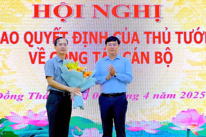 Ủy viên Trung ương Đảng, Bí thư Tỉnh ủy Đồng Tháp Lê Quốc Phong trao quyết định của Thủ tướng Chính phủ cho ông Trần Trí Quang và tặng hoa chúc mừng. (Ảnh: NHƯ ANH)