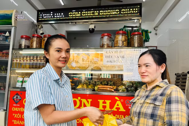 Hộ gia đình chị Phạm Tuyết Linh (bên trái), cơ sở sản xuất bánh mì và chả lụa Sơn Hà nổi tiếng hơn 40 năm qua tại Bạc Liêu ký cam kết với cơ quan chức năng thực hiện nghiêm các biện pháp an toàn thực phẩm trong dịp Tết. (Ảnh: TRỌNG DUY)