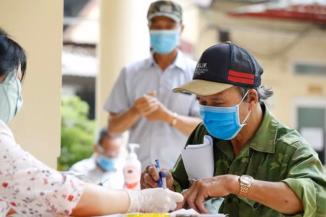 Chi trả tiền hỗ trợ dịch Covid-19 cho các đối tượng người có công và bảo trợ xã hội ở quận Đống Đa, Hà Nội vào tháng 5/2020. (Ảnh: Duy Linh)