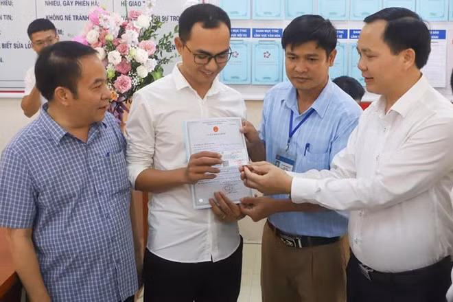 Anh Đinh Tiến Hoàng (huyện Thanh Liêm) nhận giấy khai sinh và thẻ bảo hiểm y tế cho con mới sinh, khi thí điểm hai thủ tục hành chính liên thông tại tỉnh Hà Nam, tháng 11/2022 (Ảnh: Trung Tâm)