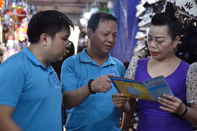 Cán bộ Bảo hiểm xã hội Hà Nội vận động người dân tham gia bảo hiểm xã hội tự nguyện, bảo hiểm y tế hộ gia đình. (Ảnh HSS) 