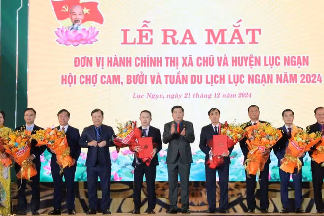Các đồng chí: Nguyễn Văn Gấu, Phan Thế Tuấn trao quyết định, tặng hoa chúc mừng lãnh đạo thị xã Chũ và huyện Lục Ngạn.