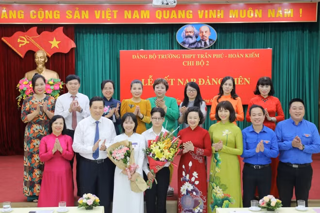Các đại biểu Thành ủy Hà Nội, Quận uỷ Hoàn Kiếm chúc mừng hai đảng viên trẻ là học sinh lớp 12 của Trường Trần Phú-Hoàn Kiếm. (Ảnh: Thế Đại.)