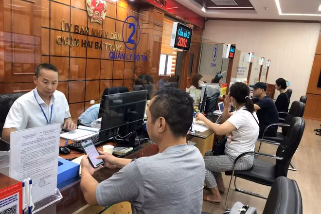 Cán bộ bộ phận Một cửa quận Hai Bà Trưng (Hà Nội) giải quyết thủ tục hành chính cho người dân. (Ảnh: BÍCH NGỌC)