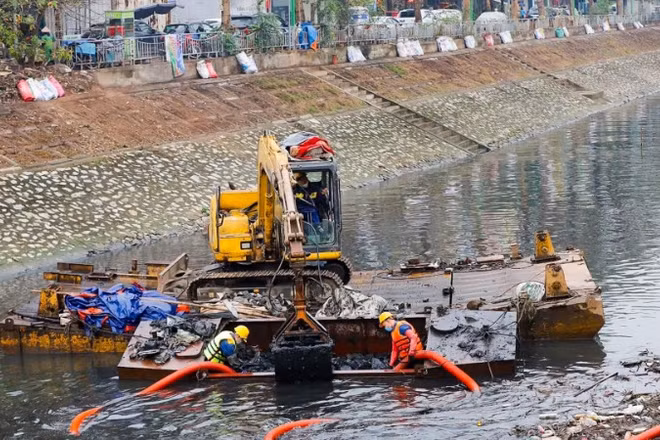 Công nhân Công ty Thoát nước Hà Nội tiến hành nạo vét bùn trên sông Tô Lịch. (Ảnh: DUY LINH)